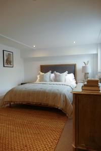 um quarto com uma cama grande com lençóis brancos e almofadas em DINCKLEY COURT Boutique Riverside Rooms em Abingdon