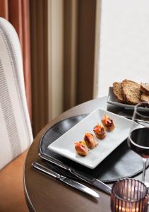 巴利布尼恩的住宿－提德布羅克酒店，桌上的一小块食物,加上一杯葡萄酒