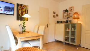 a dining room with a table and chairs and a television at Haus Wexler 2 - EG in Cuxhaven +10 photos