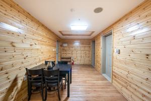 a dining room with wood paneling and a table and chairs at Chamonix Resort in Seogwipo