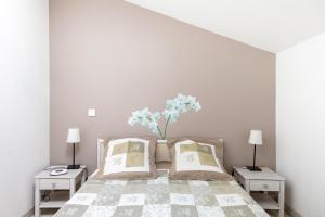 a bedroom with a bed with a vase of flowers on it at La Saumuroise in Antoigné