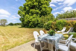 a table and chairs on a patio with a field at La Saumuroise in Antoigné