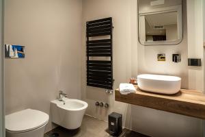 a bathroom with a sink and a toilet and a mirror at De Gulia Charme and Relax in Castellabate