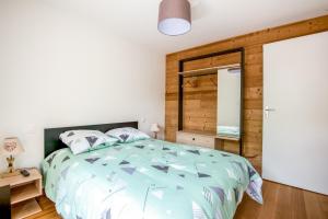 ein Schlafzimmer mit einem Bett und einer Holzwand in der Unterkunft Le Planois in La Bresse