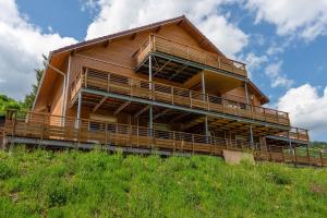 ein großes Holzgebäude auf einem Hügel in der Unterkunft Le Planois in La Bresse