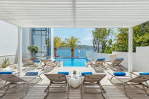 Un patio con sillas y una piscina. en Hotel Perla, en Herceg-Novi