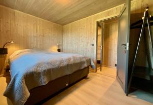 a bedroom with a bed and a door to a hallway at Haukland Beach View - Superior cabin in Leknes