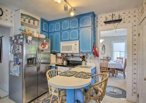 a kitchen with blue cabinets and a table and a refrigerator at Beach-Seasonstides in Scarborough