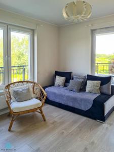a living room with a couch and a chair at Pod Brzozami Apartamenty Rezydencja Ustronie Morskie in Ustronie Morskie