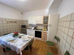 eine Küche mit einem Tisch und Stühlen sowie einem Kühlschrank in der Unterkunft Secret Garden Egle in Caprino Veronese