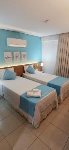 Blanco Beach Suite Privada, Cumbuco في كومبوكو: سريرين في غرفة الفندق عليها مناشف
