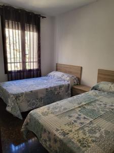 - une chambre avec 2 lits et une fenêtre dans l'établissement Apartamento San Andres, à Calatayud