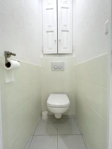 bagno bianco con servizi igienici e armadietto. di Cosy T2 Saint Martin Vésubie a Saint-Martin-Vésubie