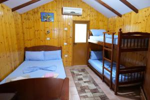 Zimmer mit 2 Etagenbetten und einem Stuhl in der Unterkunft GuestHouse Hamiti Llogara in Vlorë