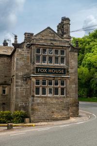 un viejo edificio de piedra con un cartel de casa de zorro. en The Fox House by Innkeeper's Collection, en Hathersage