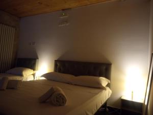 1 dormitorio con 2 camas con sábanas y almohadas blancas en Antadia Duomo Monreale, en Monreale