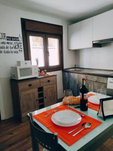 una cocina con una mesa con un plato y una botella de vino en El Rincón del Alma Mía, en Simancas