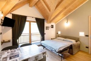 a bedroom with a bed and a large window at Appartamento Salient Casa Campacc in Livigno