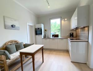 a kitchen and living room with a couch and a table at Haus Kranenborgh im Kamerun Steinhude am Meer in Steinhude