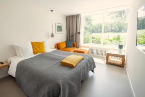a bedroom with a large bed and a window at Villa de Hazelaar in Schoorl