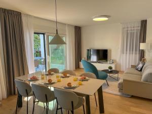 ein Wohnzimmer mit einem Tisch und Stühlen sowie ein Wohnzimmer in der Unterkunft Zadar Premium Apartments in Kožino