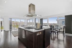 a kitchen with a stove and a dining room with windows at The Penthouse - By Howburn Residence in Aberdeen