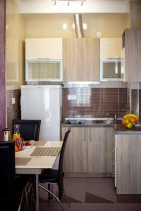 a kitchen with a table and a white refrigerator at SunSea Apartments in Budva