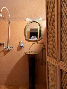 uma casa de banho com um lavatório e um espelho em La Fibule D'or em Aït-Ben-Haddou