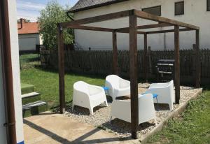 a gazebo with white chairs and a piano at Majorka in Tiszafüred