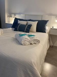 羅薩里奧的住宿－Suites Quality 2 - Rosario，一张白色的床,上面有两条毛巾