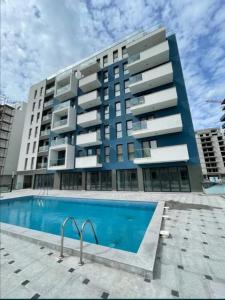 un grand bâtiment avec une piscine devant dans l'établissement Studiou Andu Nord 10 by Alezzi, à Năvodari