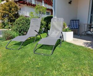 three chairs sitting on the grass in a yard at Ferienglück Unterkirnach in Unterkirnach