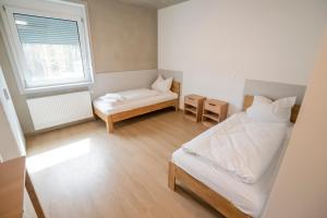 ein kleines Schlafzimmer mit einem Bett und einem Fenster in der Unterkunft SITE.INN Denkendorf in Denkendorf