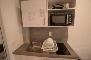 eine Küchentheke mit Spüle und Mikrowelle in der Unterkunft SITE.INN Denkendorf in Denkendorf + 4 Fotos