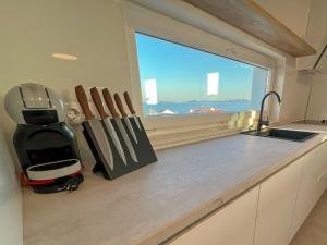 a kitchen with a counter with knives and a window at Zadar Premium Apartments in Kožino