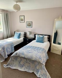 a bedroom with two beds and a mirror at St Andrews Golf and holiday home in St. Andrews