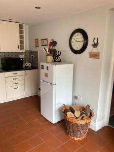 a kitchen with a white refrigerator and a clock on the wall at Charming 1-Bed Studio in Middlesbrough in Middlesbrough