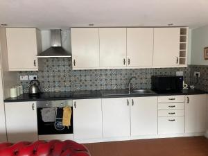 a kitchen with white cabinets and a sink at Charming 1-Bed Studio in Middlesbrough in Middlesbrough