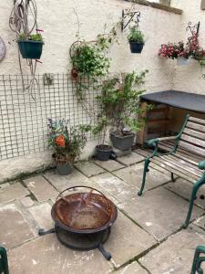 a fire pit next to a bench and potted plants at Charming 1-Bed Studio in Middlesbrough in Middlesbrough