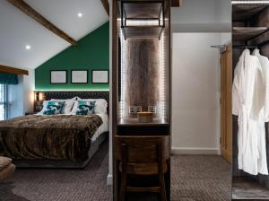 The Swan Inn في Highpeak Junction: غرفة نوم بسرير وجدار أخضر