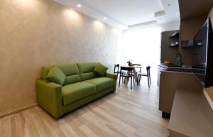 um sofá verde numa sala de estar com uma mesa em Vilu Suite Centro em Polignano a Mare