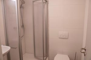 La salle de bains est pourvue d'une douche, de toilettes et d'un lavabo. dans l'établissement SITE.INN Denkendorf, à Denkendorf