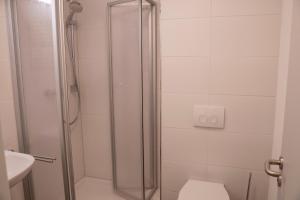 ein Badezimmer mit Dusche, Toilette und Waschbecken in der Unterkunft SITE.INN Denkendorf in Denkendorf