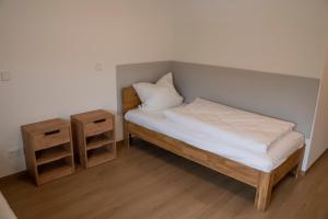 ein kleines Schlafzimmer mit einem Bett und zwei Nachttischen in der Unterkunft SITE.INN Denkendorf in Denkendorf