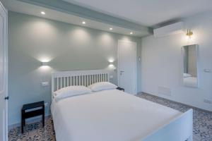 1 dormitorio con 1 cama blanca grande y espejo en Gli Ulivi Rooms And Breakfast, en Andora