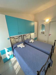 a bedroom with two blue beds and blue cabinets at Veranda sul Paradiso in Costa Paradiso