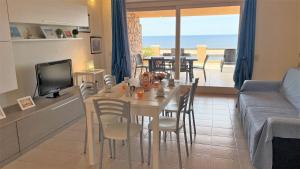 a kitchen and living room with a table and a couch at Veranda sul Paradiso in Costa Paradiso