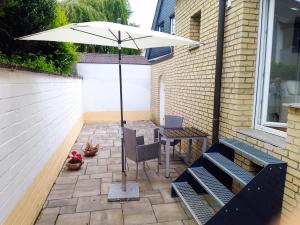 a patio with an umbrella and a table and chairs at Zentrale ruhige Lage mit Parkplatz und Terrasse in Bad Honnef am Rhein