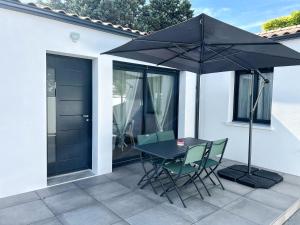 - une table et des chaises avec un parasol sur la terrasse dans l'établissement Le Prieuré, à La Rochelle