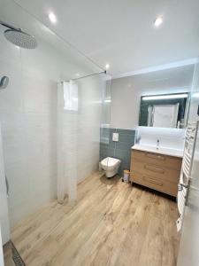 La salle de bains est pourvue de toilettes, d'un lavabo et d'un miroir. dans l'établissement Le Prieuré, à La Rochelle